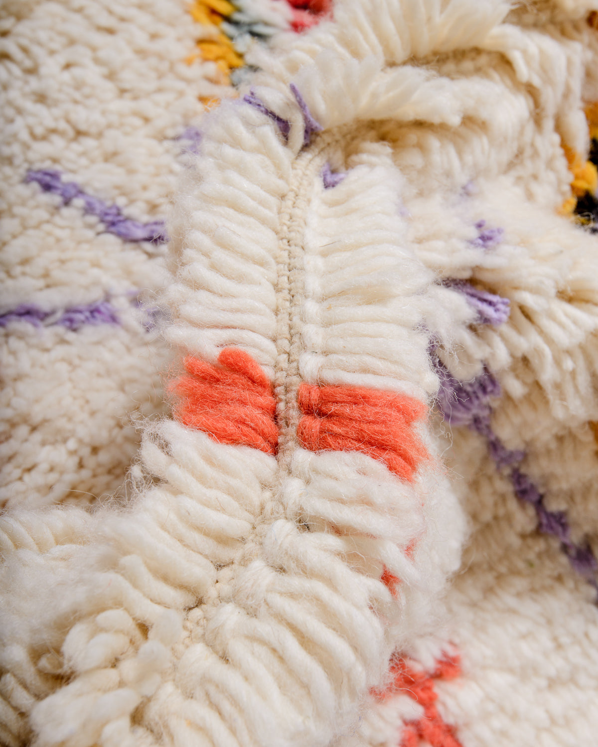 Detail of fluffy wool in cream, yellow, lavender and coral.